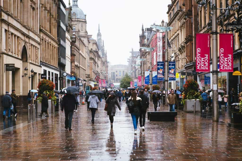 A group of people walking down a street holding umbrellas