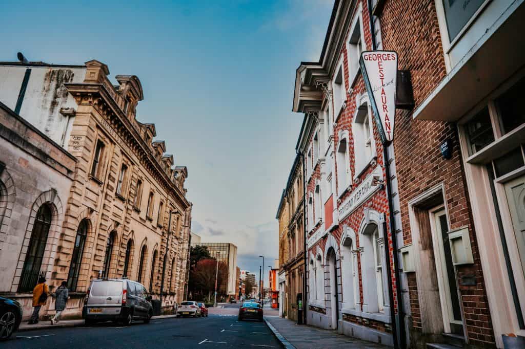 Cars parked beside brown concrete building during daytime